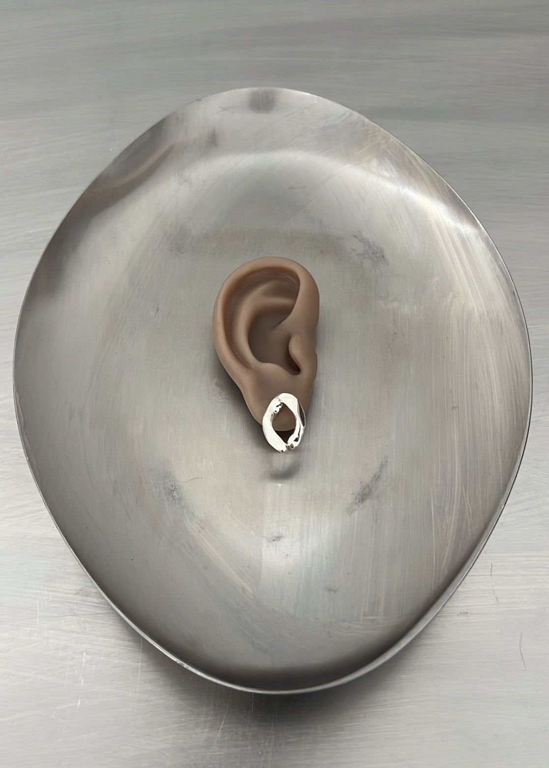 Stylized ear on a metallic surface