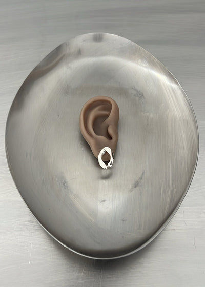 Stylized ear on a metallic surface