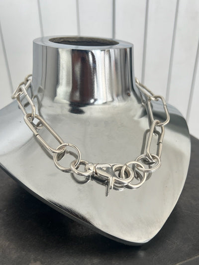 Silver chain necklace on a metallic mannequin bust.