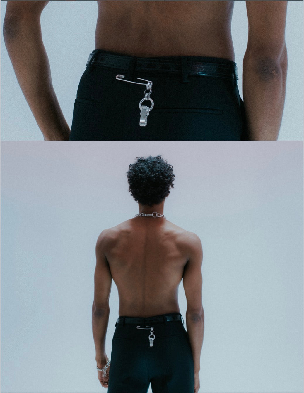 Silver safety-pin style accessory with rolo chain detail . on model